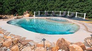 Finished sand sculpted pool with freeform shoreline and boulders