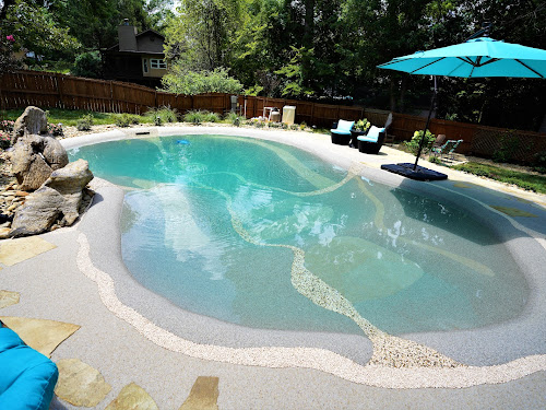Sand sculpted pool with pebble beach and boulder outcrop