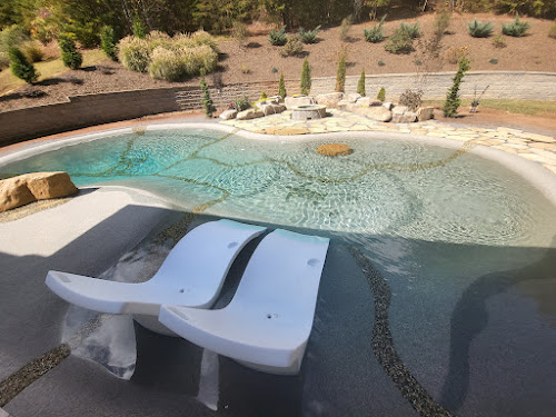 In-water loungers on the shallow shelf of a sand sculpted pool