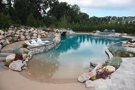 Sand sculpted pool with grotto, boulder walls and sand beach