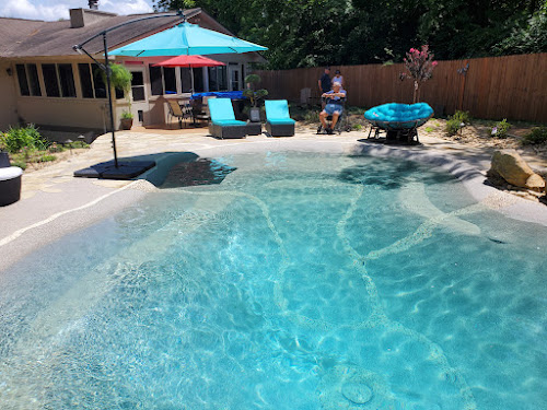 Family relaxing beside their finished sand sculpted pool