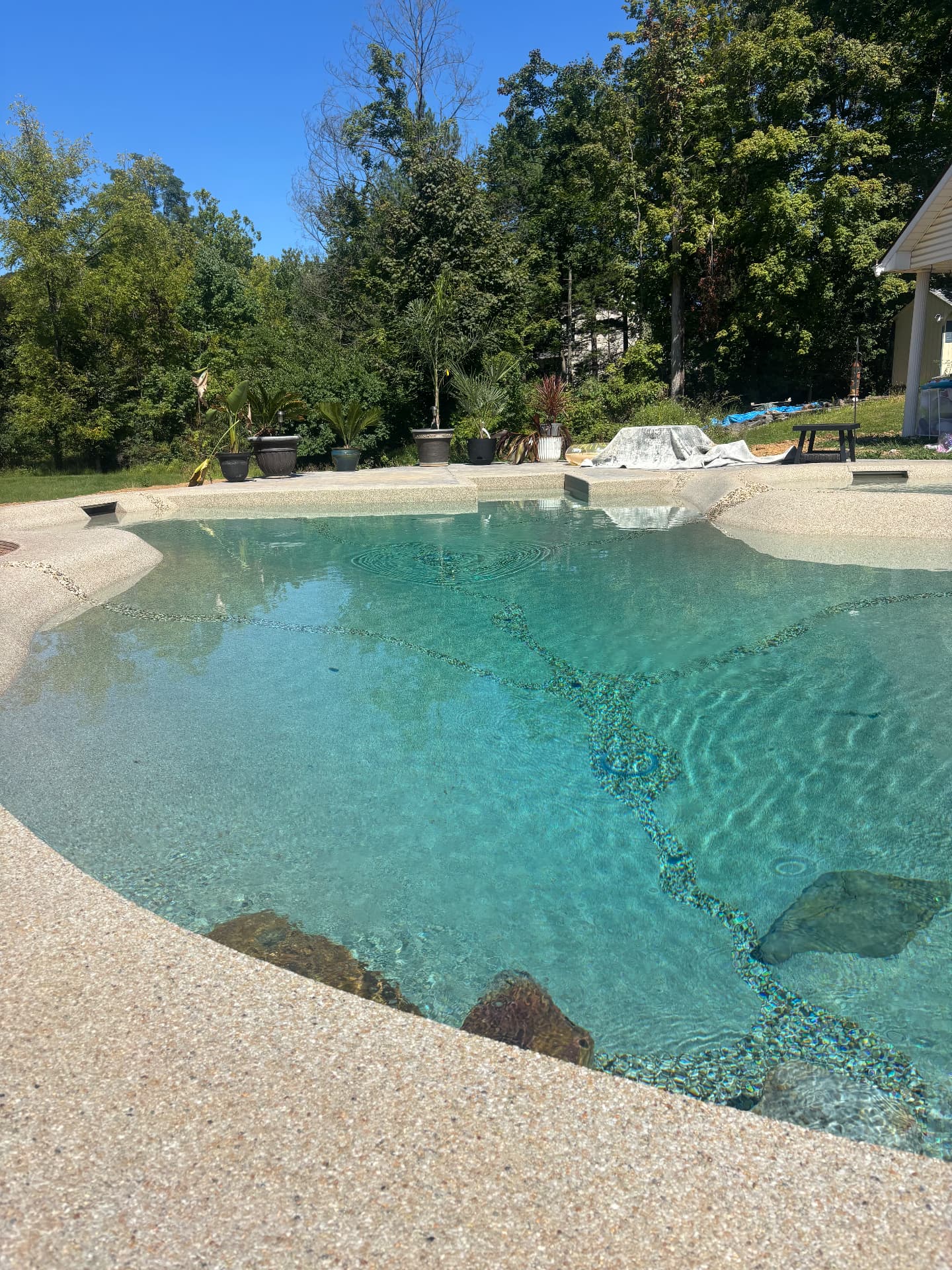 The finished beach entry sloping into clear mineral-finished water