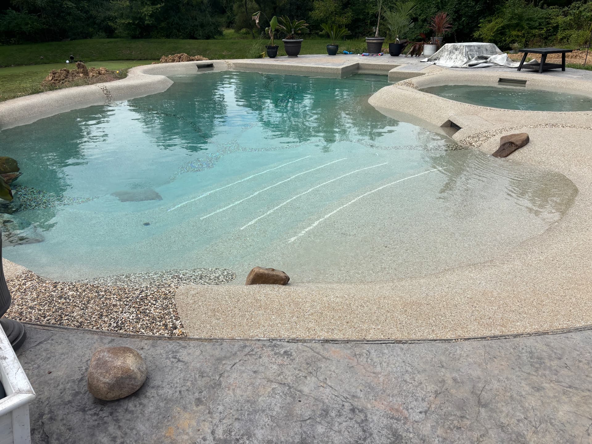 Wide view of the finished sculpted pool with the walk-in beach entry